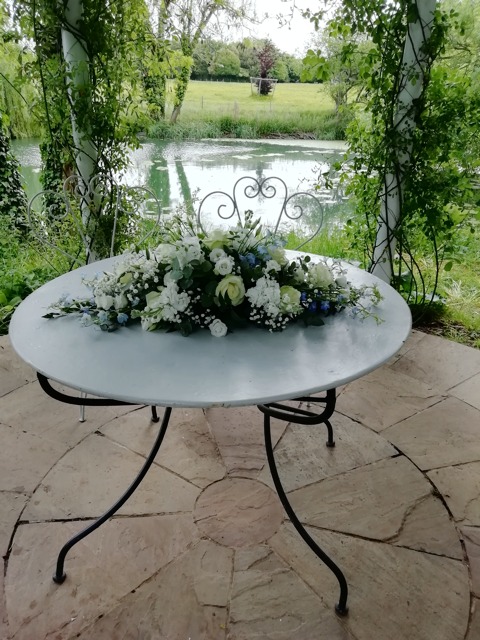 white floral wedding display on outside table by river